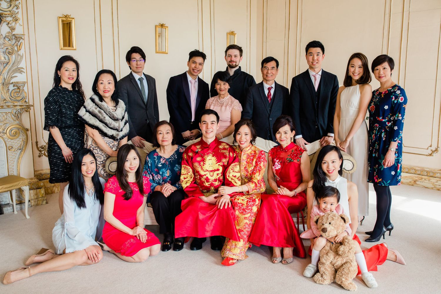 Bride and groom with both families – relaxed group photo at Gosfield Hall Essex