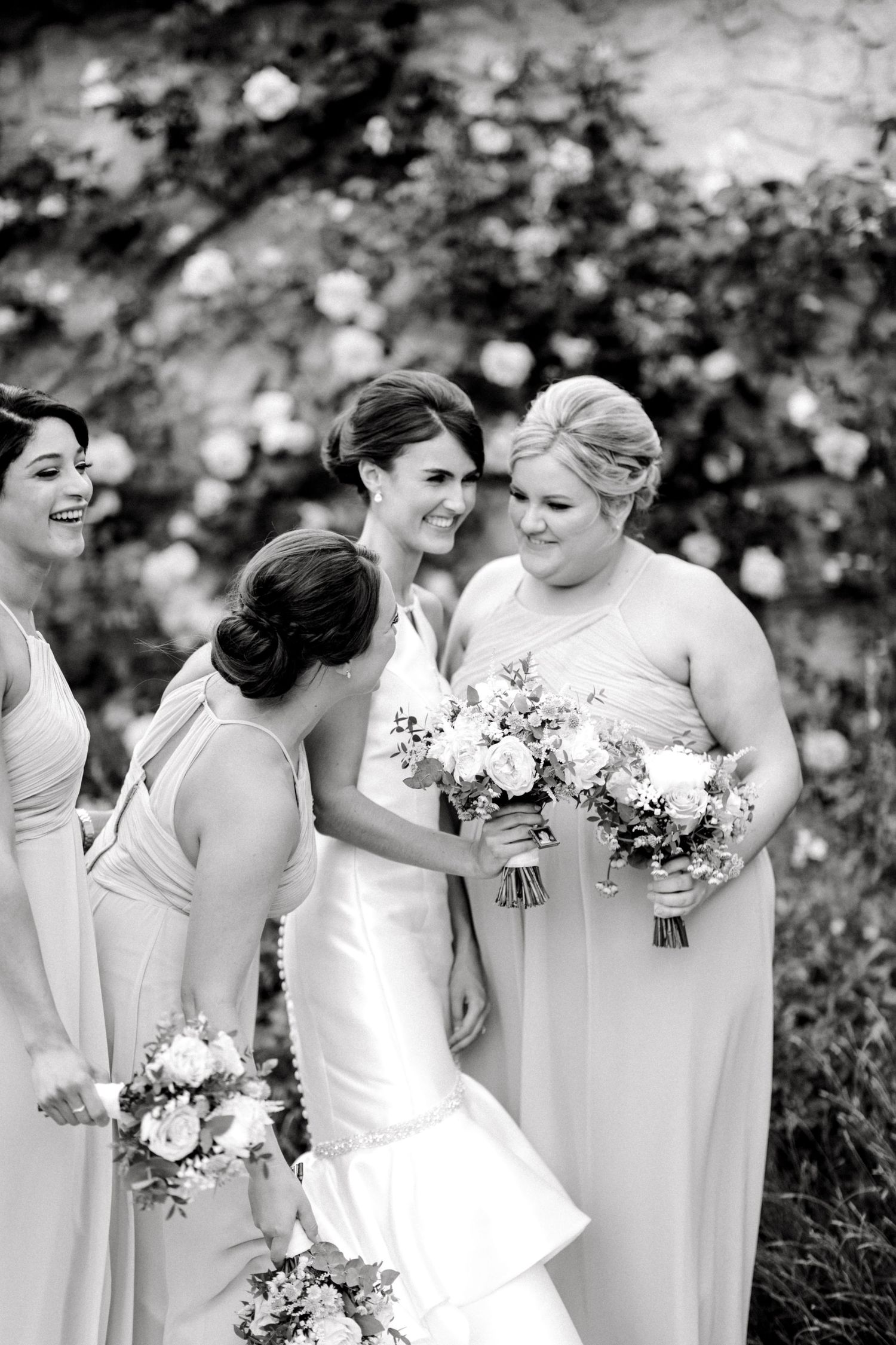 Bride surrounded by laughing bridesmaids candid group photo in reception venue in Kent