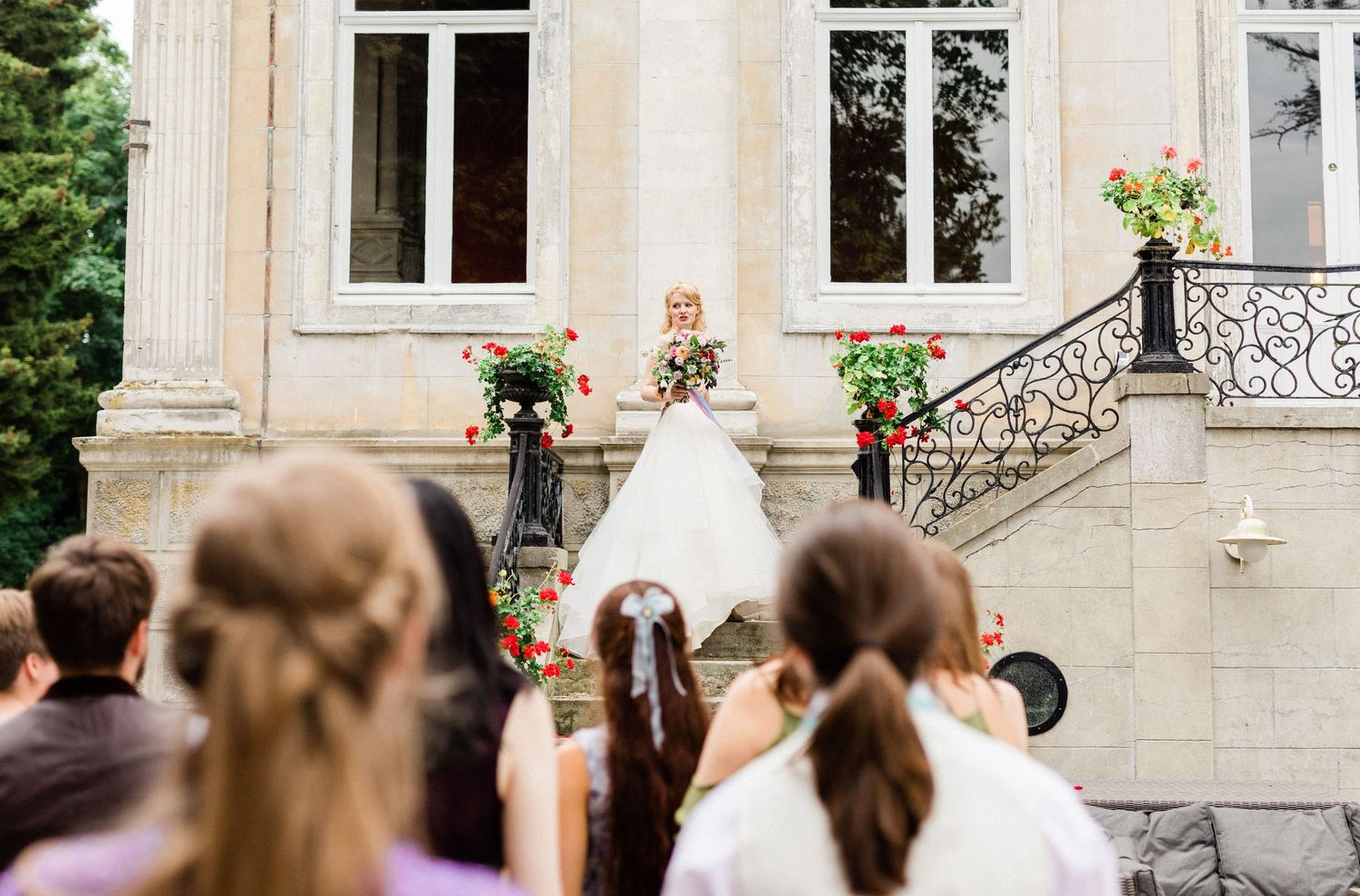 joyful moment as bride gets ready to toss bouquet to waiting bridesmaids in a chateau in France