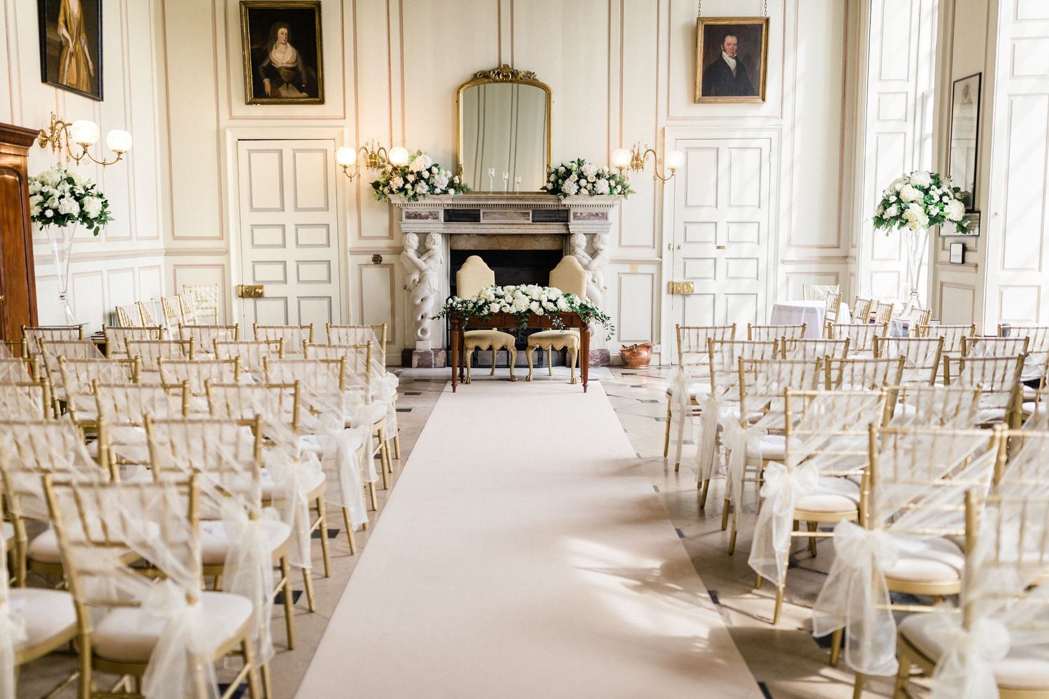 Beautiful wedding ceremony room setup with elegant decor and floral arrangements in Gosfield Hall Essex
