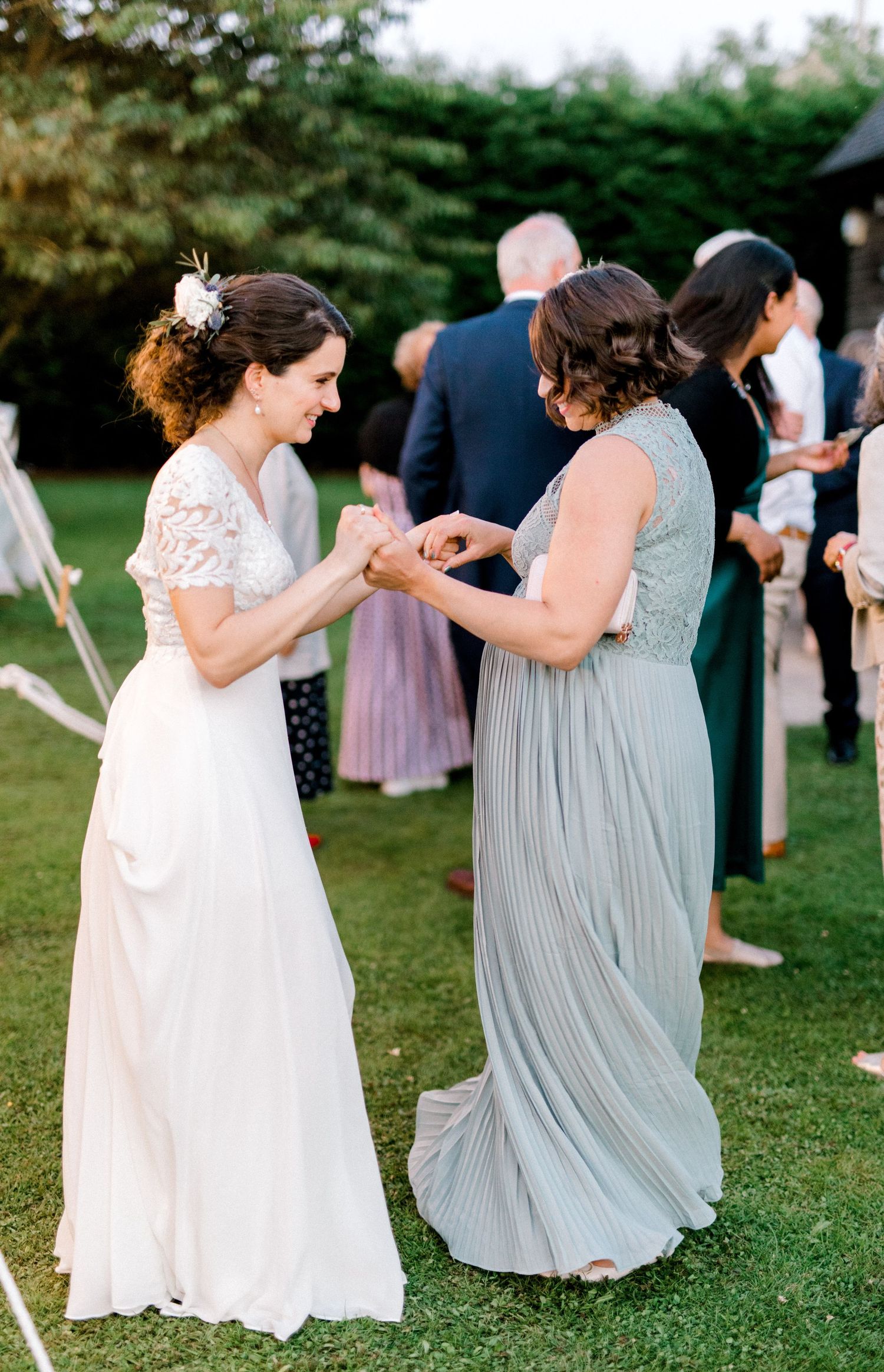 Candid moment of bride and best friend laughing on the dance floor in London