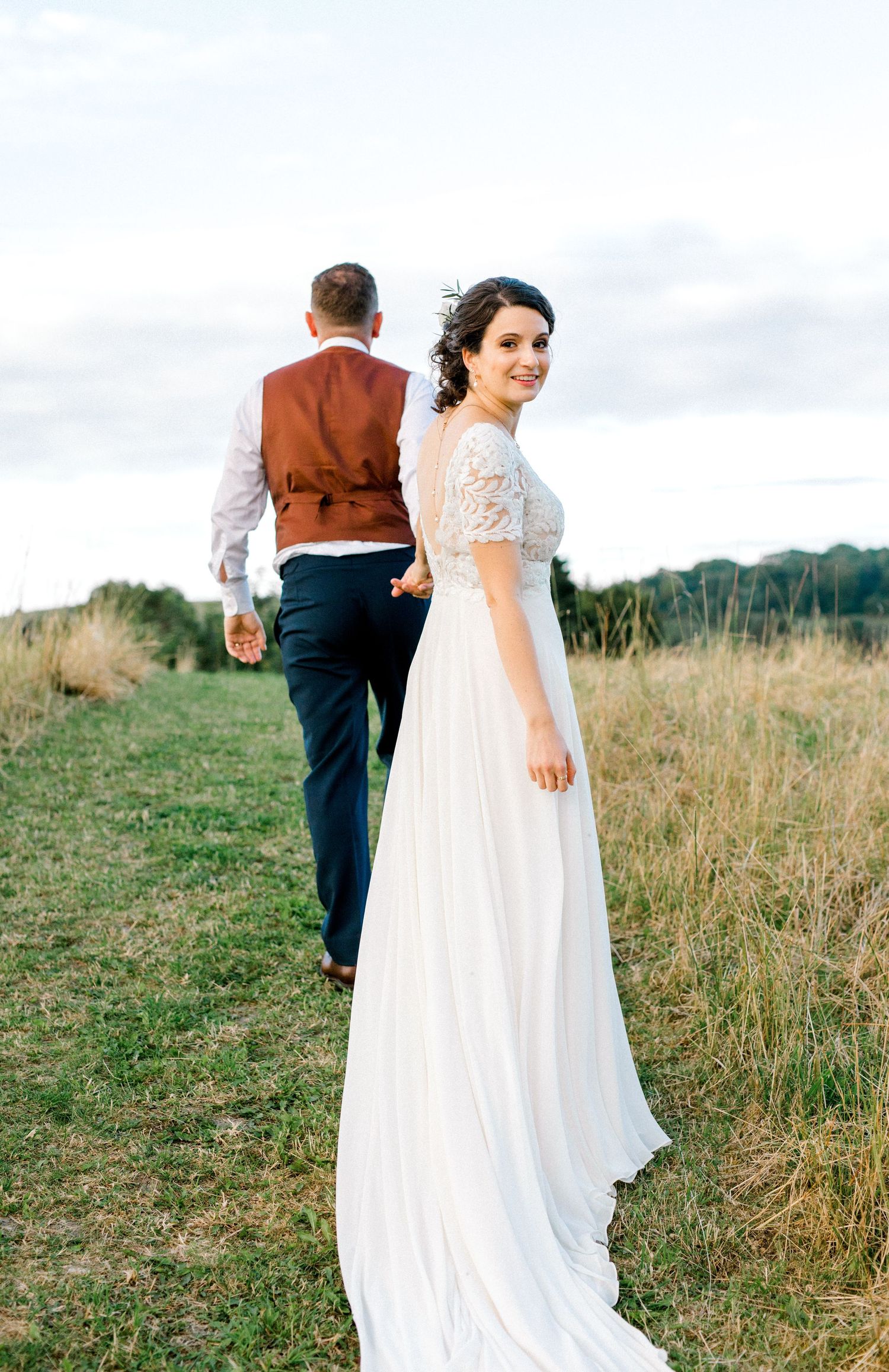Wedding couple portrait with groom walking ahead and bride looking over shoulder at camera in London
