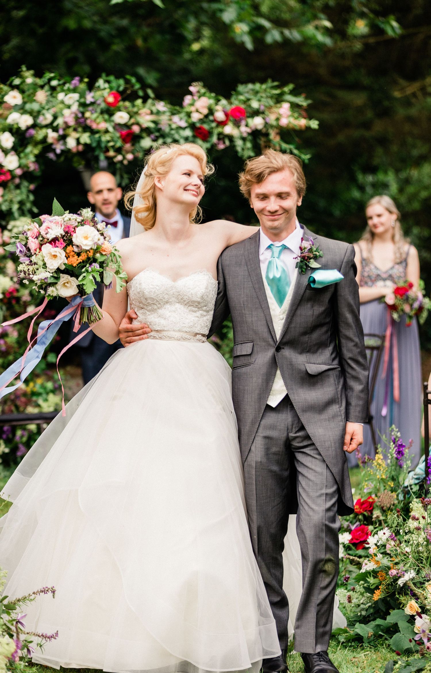 Newlyweds’ joyful aisle exit surrounded by cheering family and friends