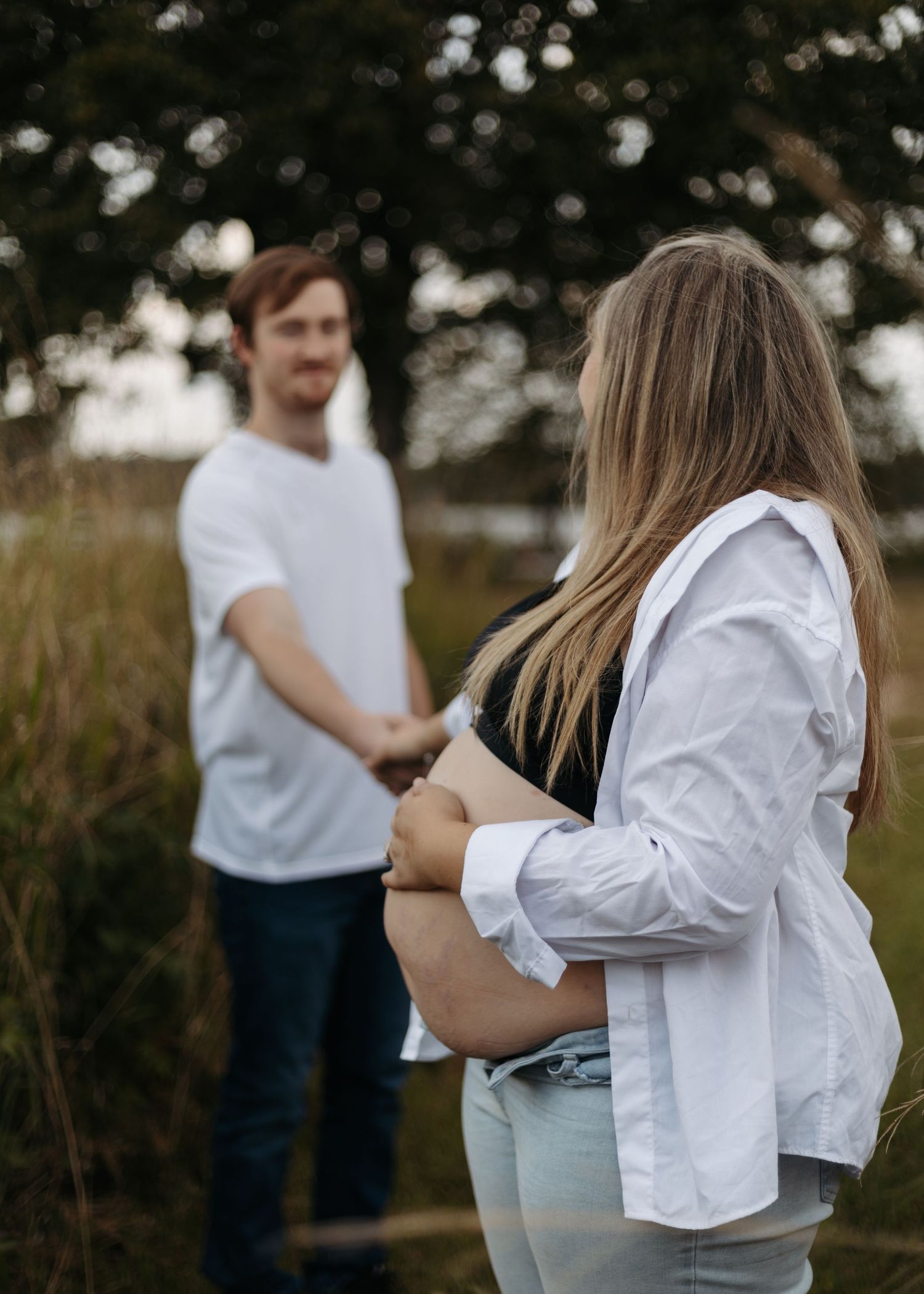 A series of photos showing people embracing in casual white shirts against a natural outdoor backdrop.