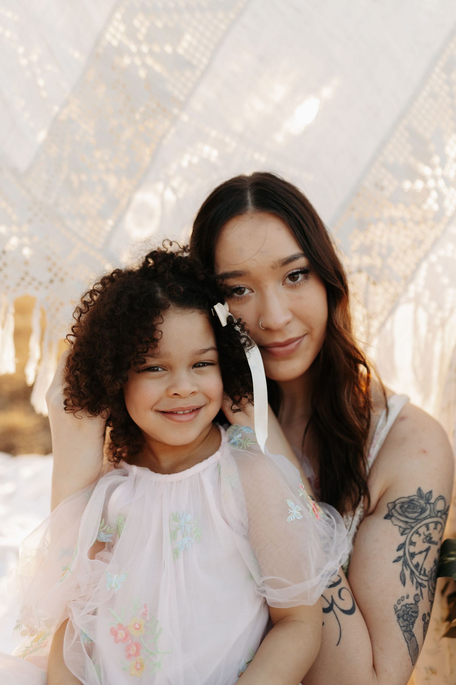 Two friends pose together in a series of candid shots with soft lighting and white clothing.