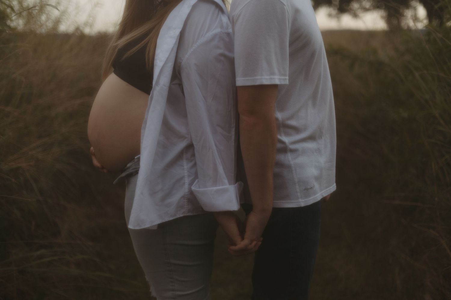 A romantic series of photos showing a couple in white outfits embracing against a dimly lit outdoor background.
