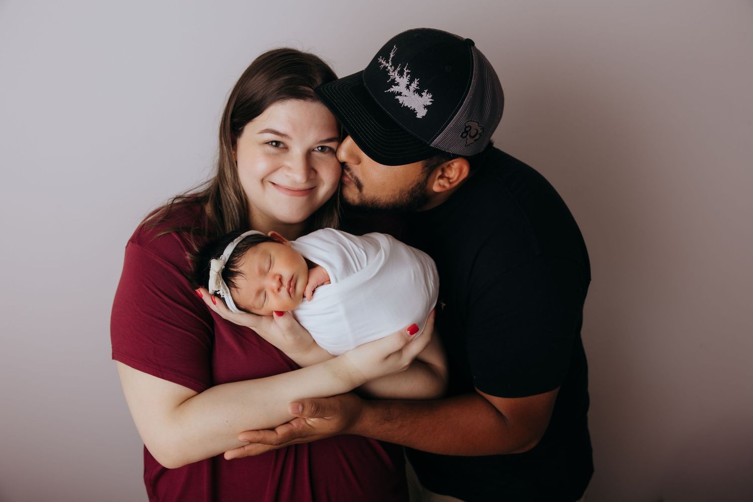 A series of intimate family portraits showing tender moments between parents and their newborn baby.