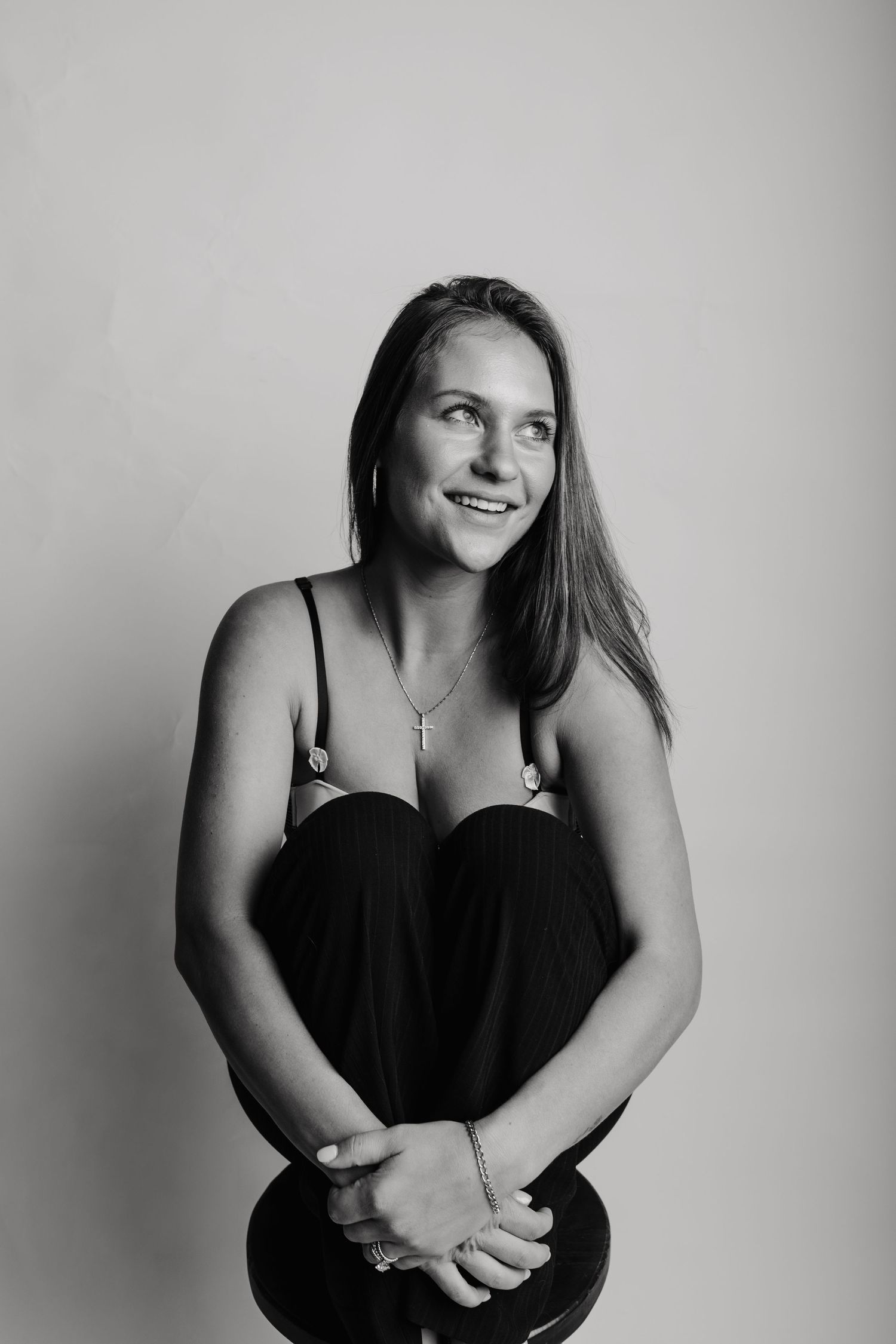 A series of black and white portraits showing a person in a dark sleeveless top expressing different emotions and poses.