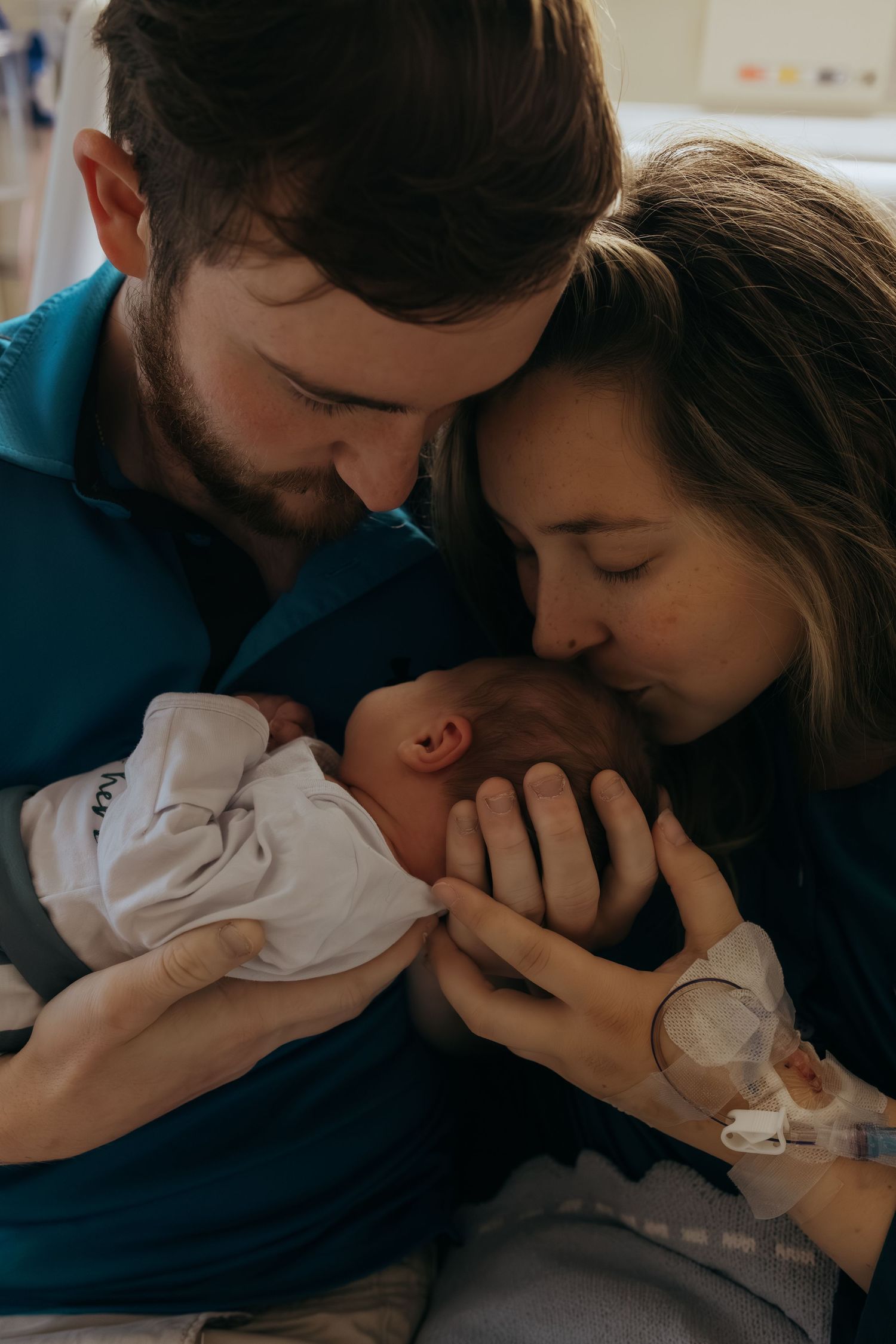 A tender moment between parents and their newborn baby shown in a series of intimate black and white photographs.