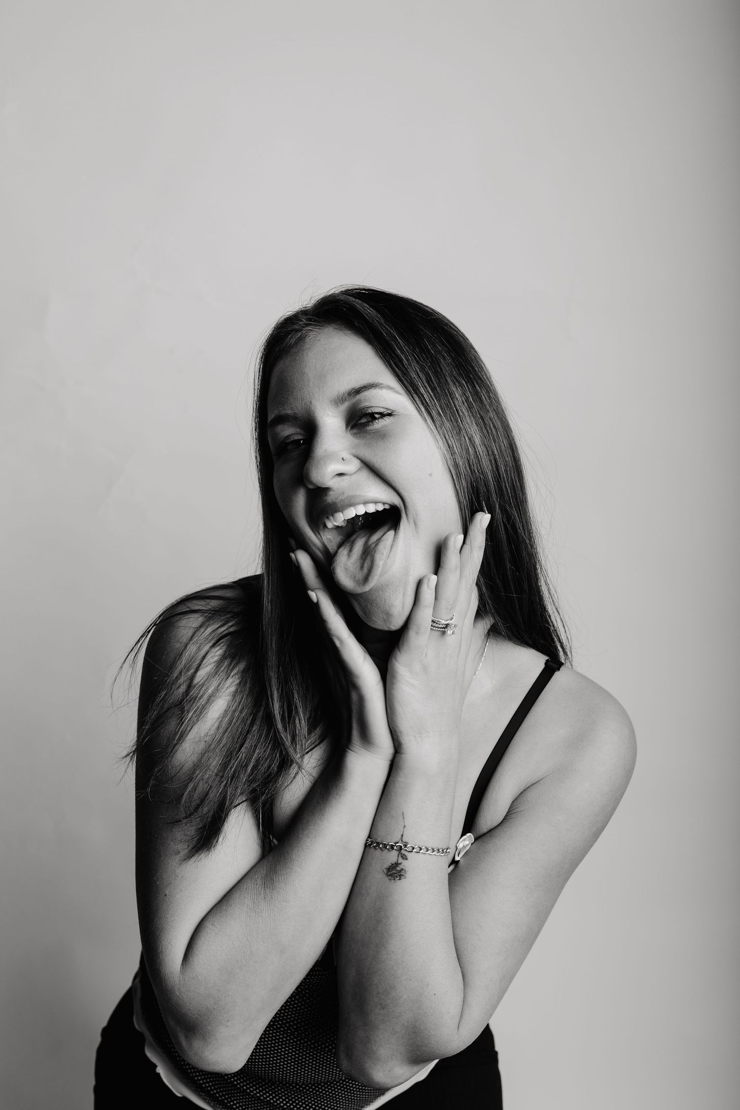 A black and white photo series shows a person laughing joyfully with natural expressions and hand gestures.