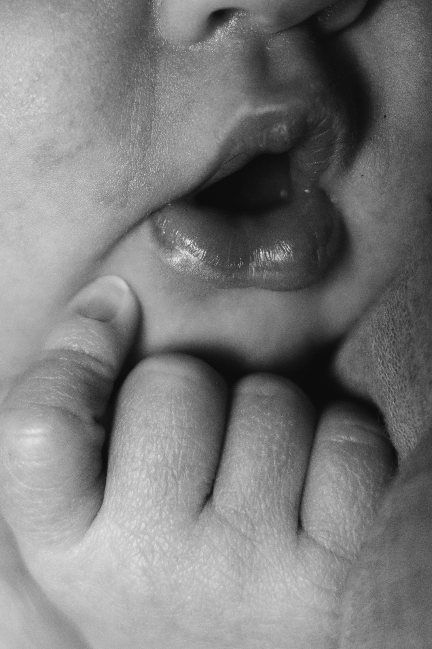 A series of close-up black and white photographs showing different angles of lips and fingers in an artistic composition.