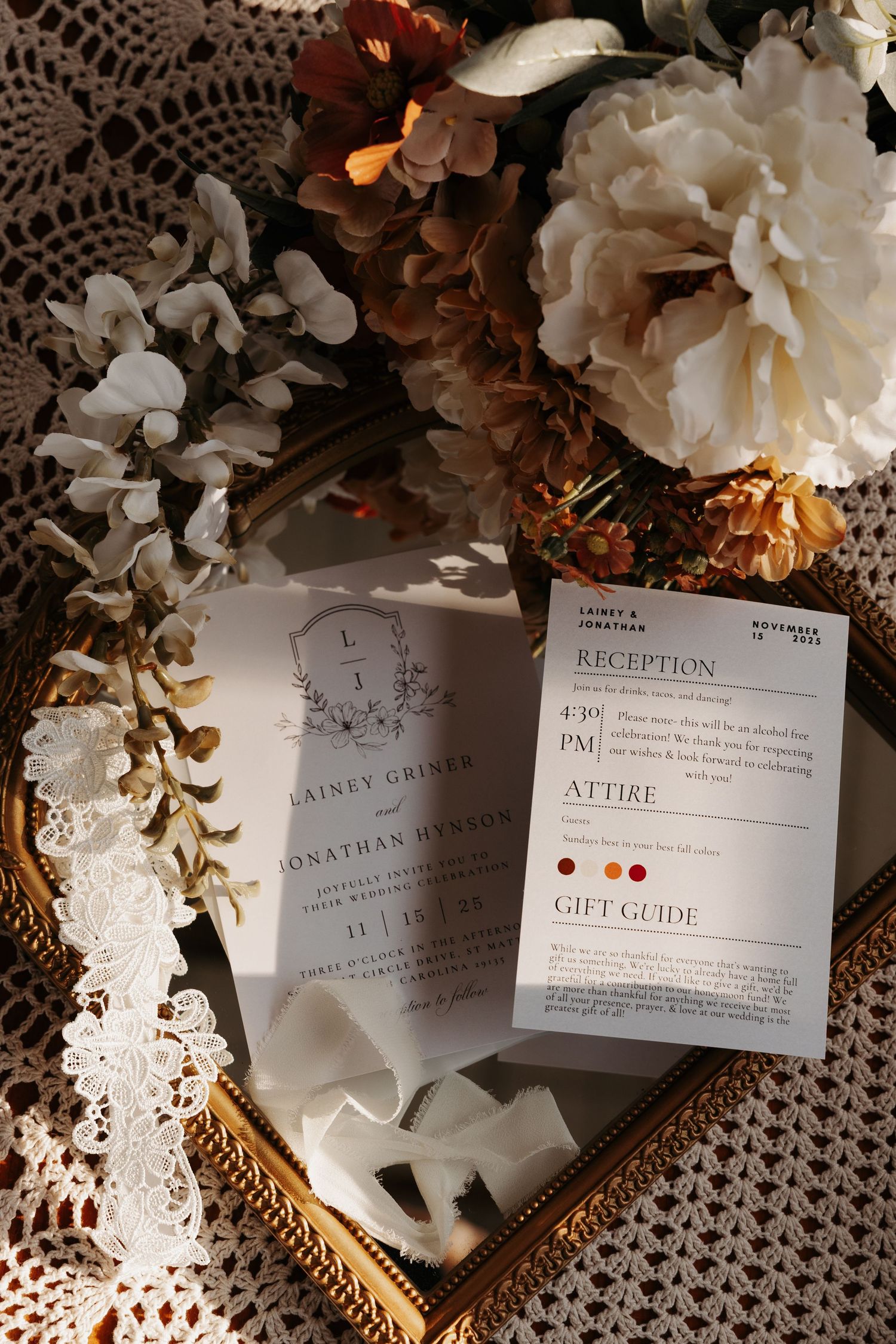 Elegant wedding invitation suite with floral decor on a gold tray, featuring reception details and attire guide.