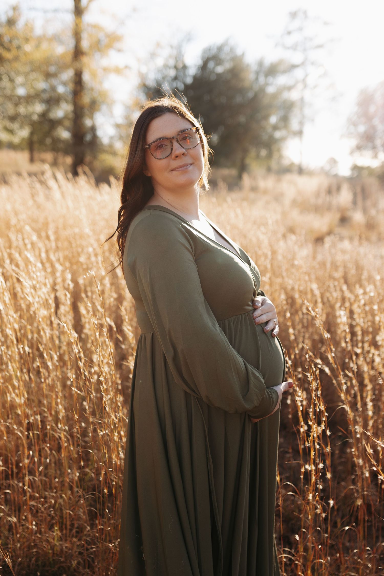 A figure stands in a golden field at sunset wearing a dark green cardigan, creating a dreamy autumn portrait series.
