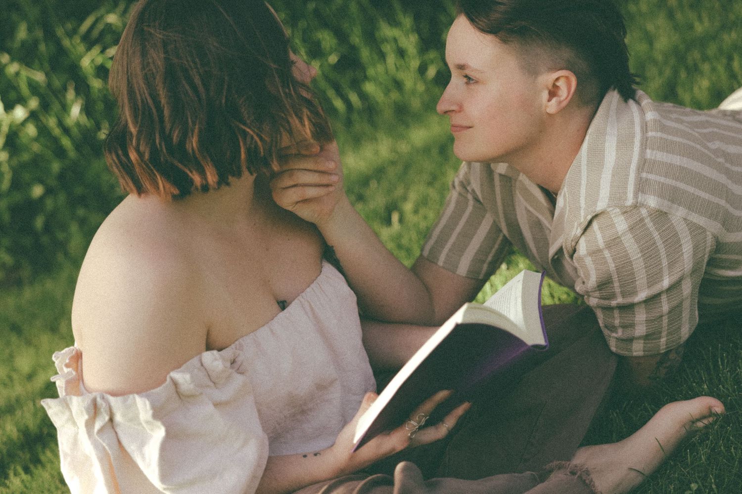 A tender moment between partners reading together in soft natural light.