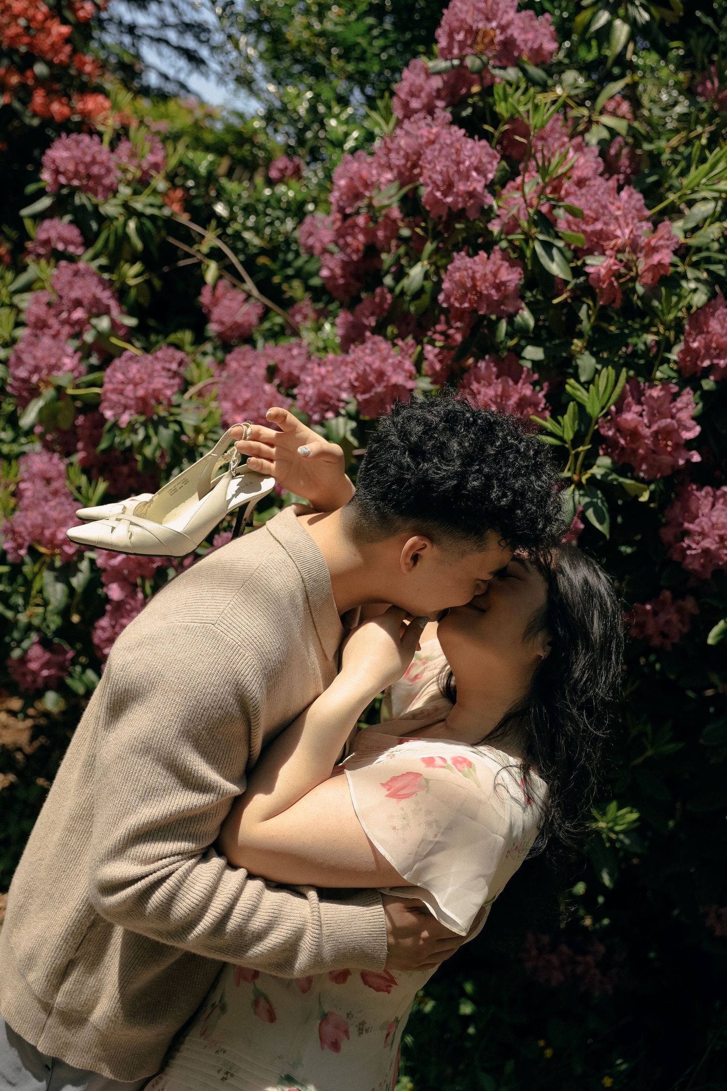 A romantic scene with pink flowering bushes in the background.