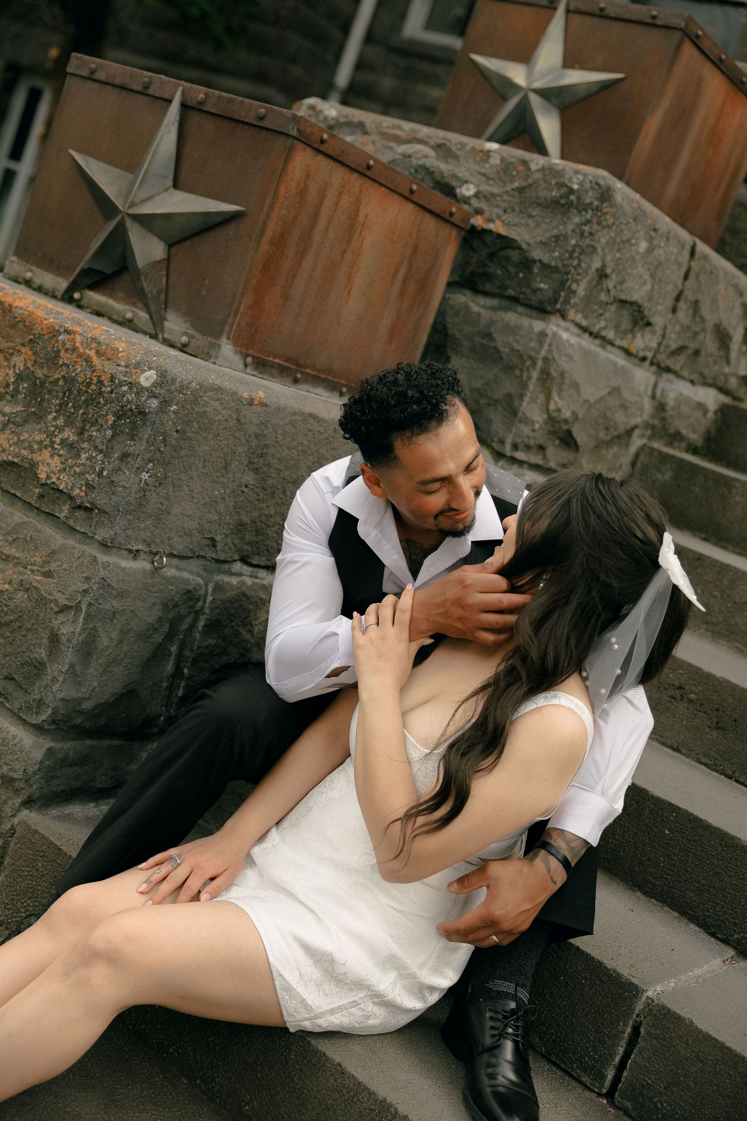 A romantic couple sharing an intimate moment on rustic stone steps during their wedding.