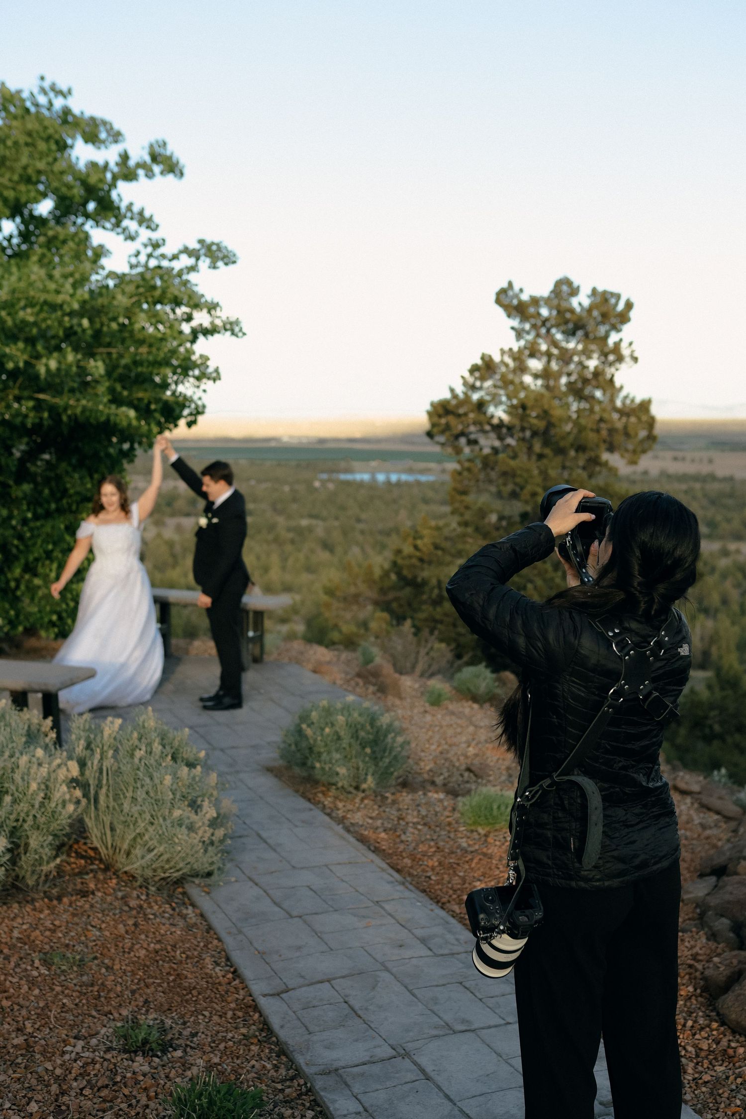 Photographers capture a couple during a desert photo shoot at sunset.