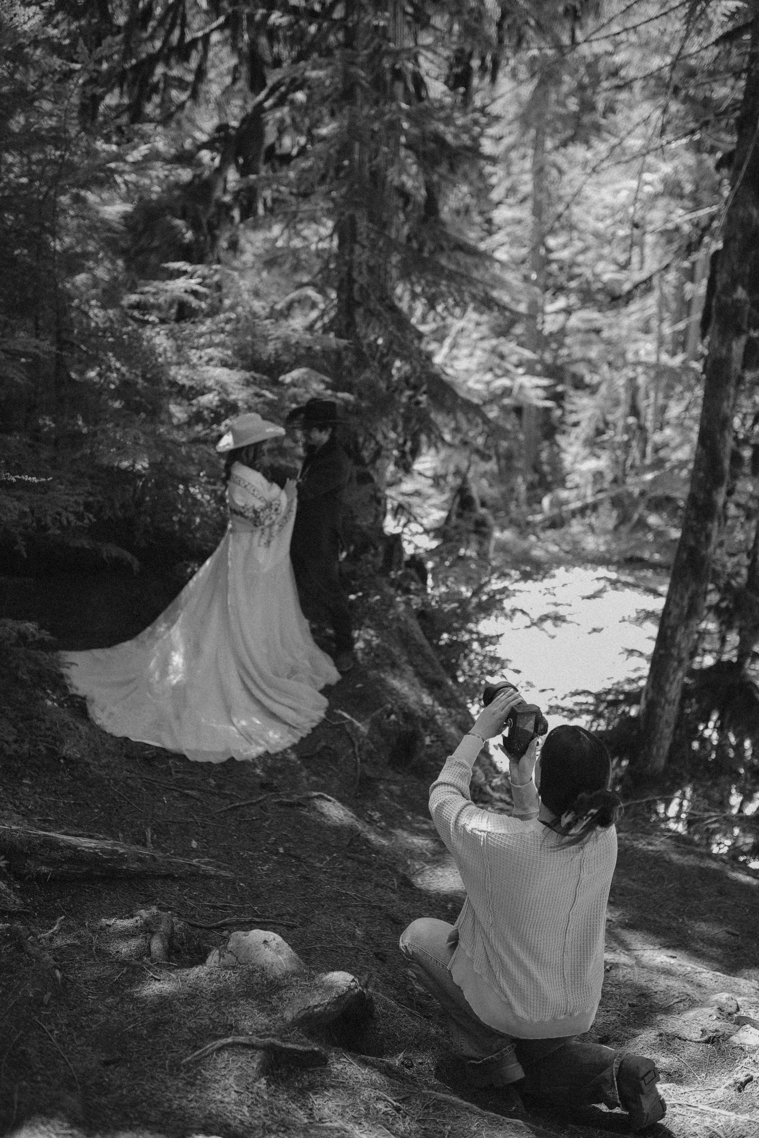 Photographer taking artistic shots in a misty forest setting.