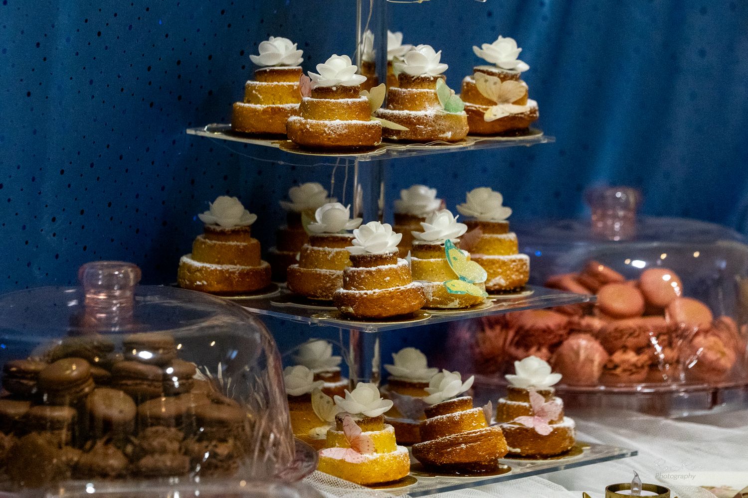 Multi-tiered display of mini desserts topped with whipped cream at an elegant event.