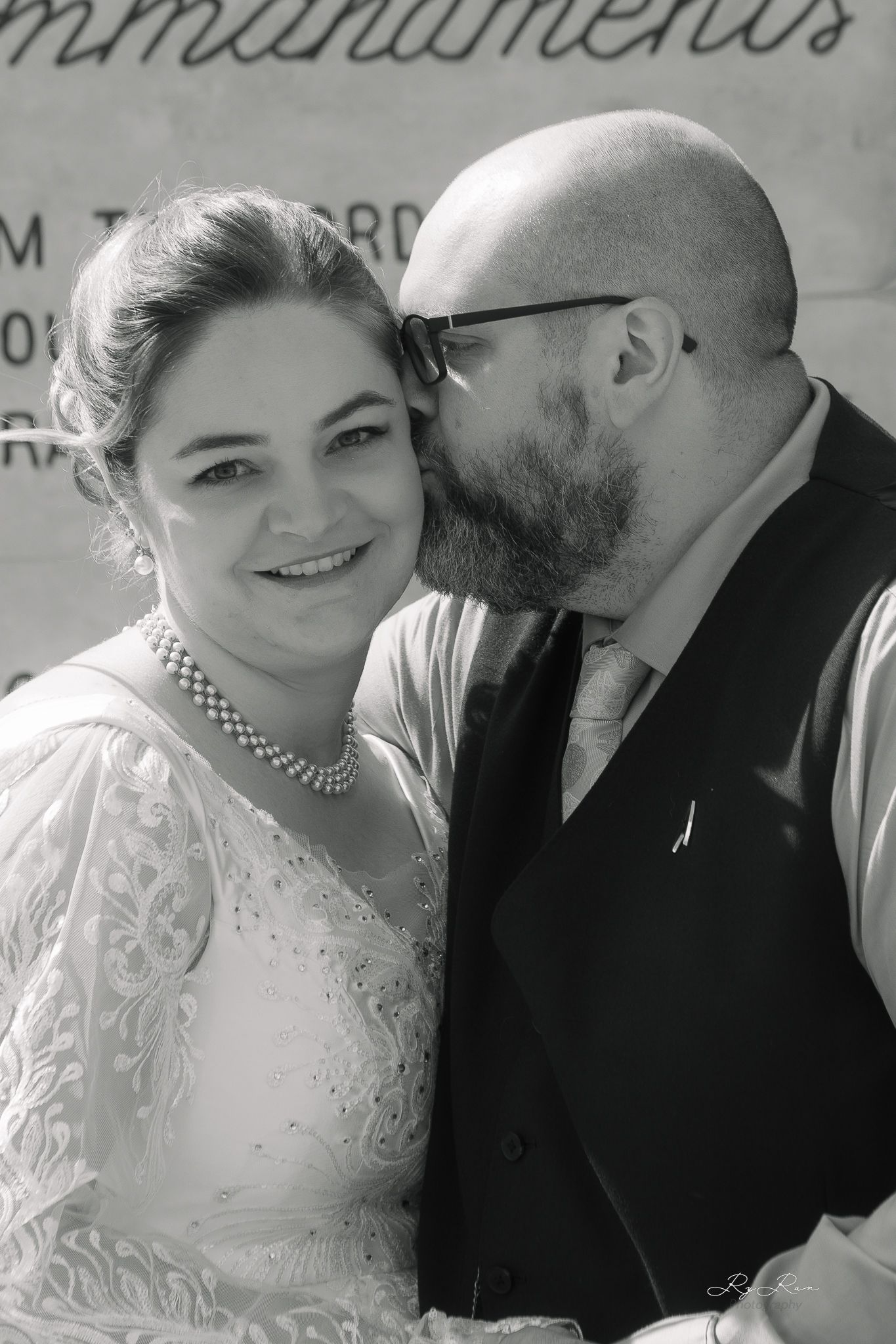 A black and white intimate wedding portrait showing tender affection.