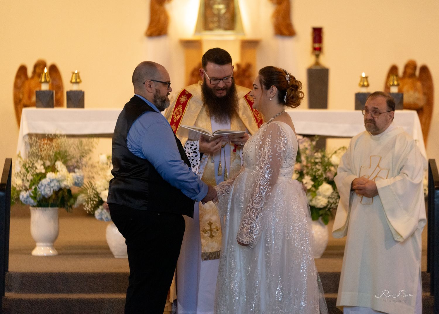 A wedding ceremony takes place at an altar with clergy members and a couple exchanging vows.