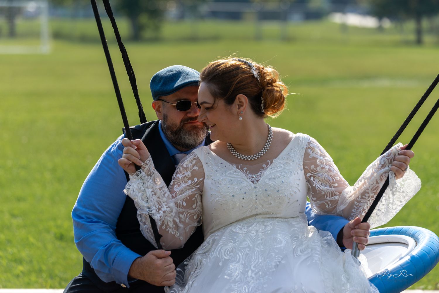 Romantic couple sharing a tender moment on a playground swing.
