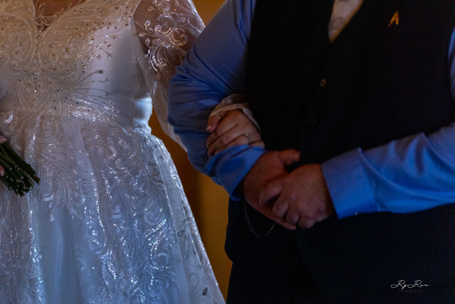 Close-up detail of joined hands during a wedding ceremony.