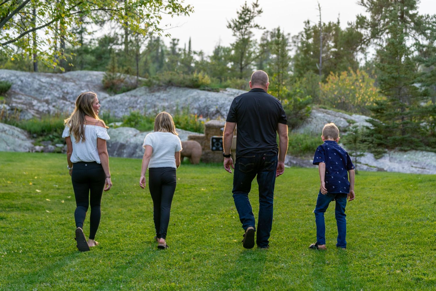 Family enjoying outdoor walk together in natural setting with rocky landscape.