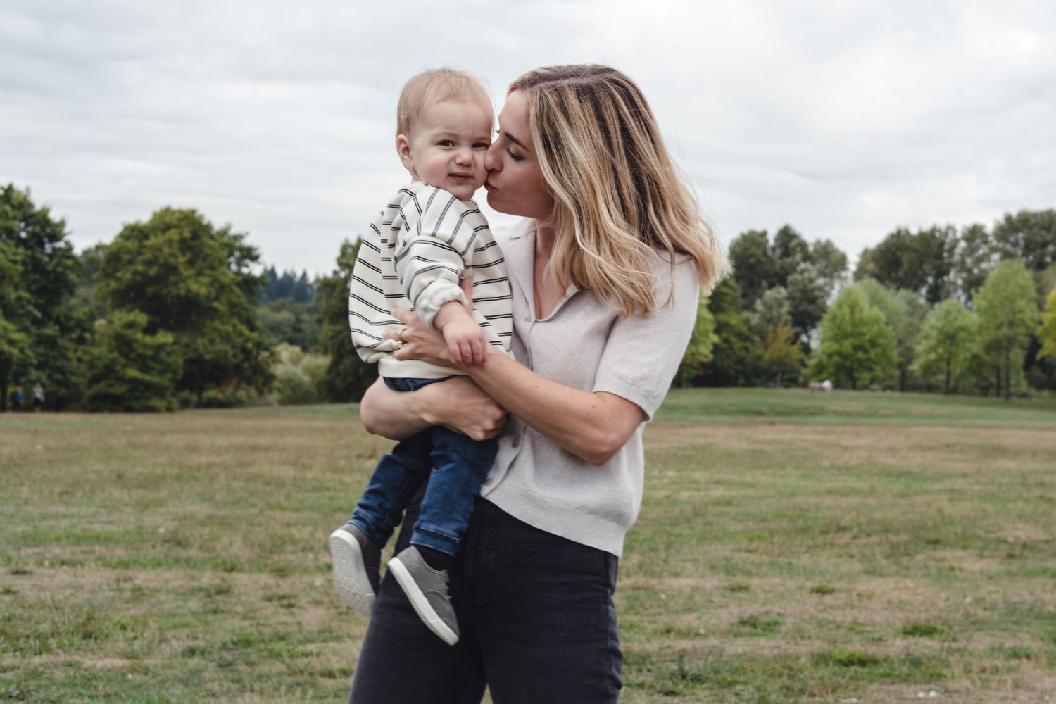 A joyful outdoor moment between parent and child in a grassy field.