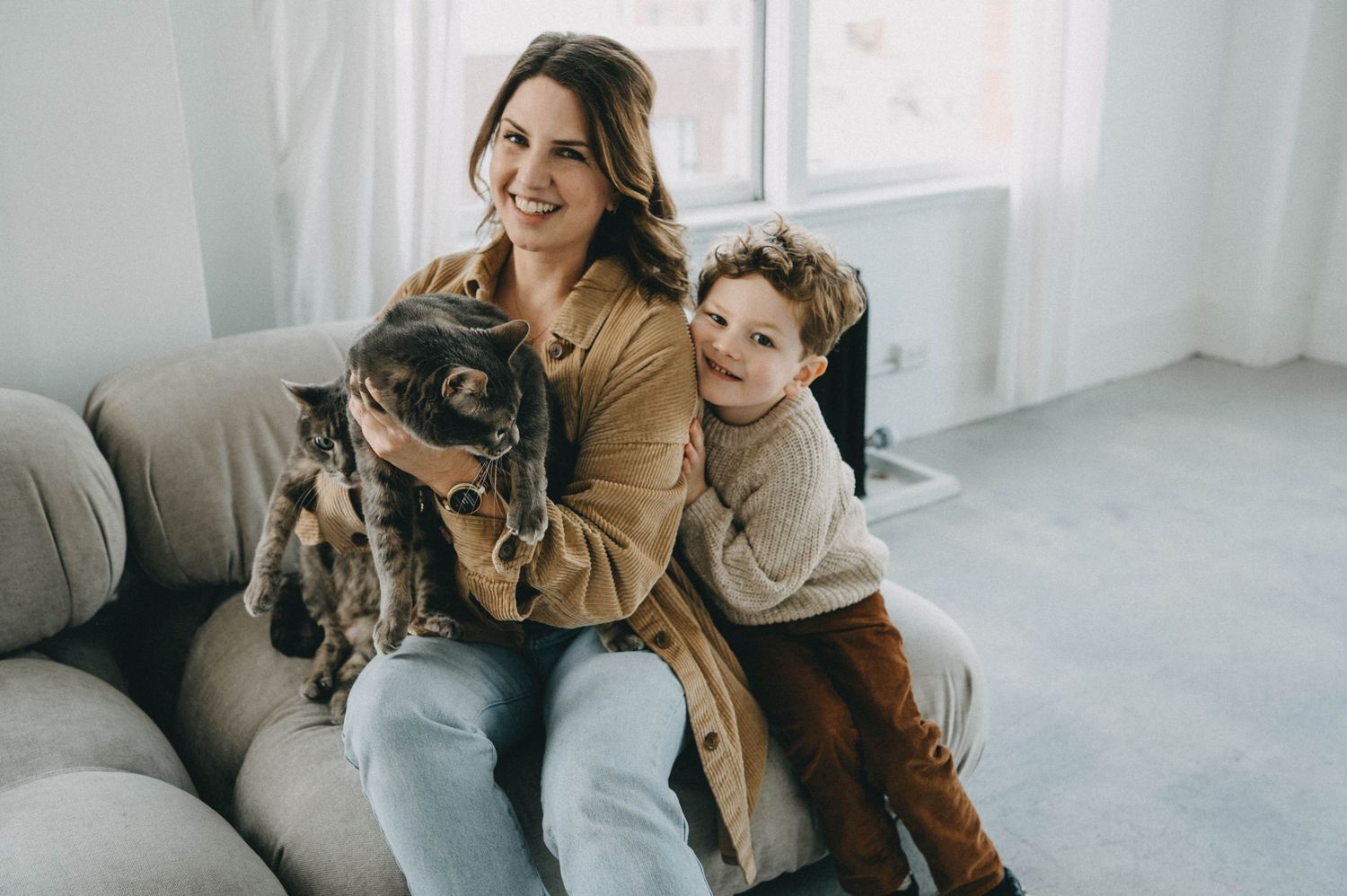 A cozy family moment on the sofa with a furry black dog.