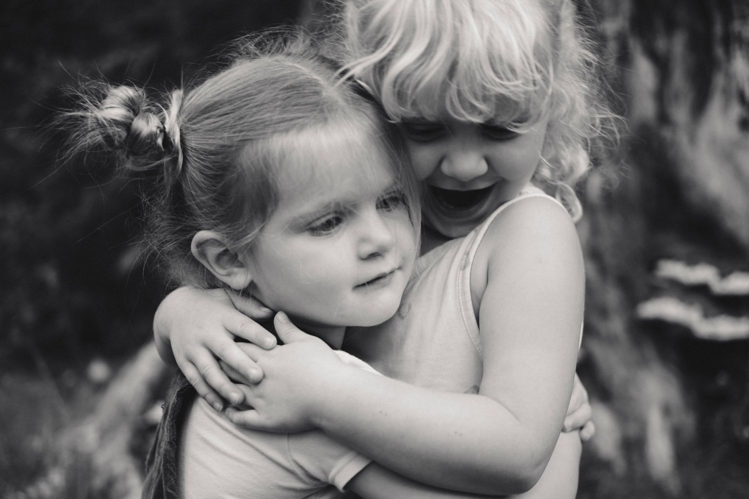 A series of black and white photos showing tender embraces and affectionate moments between parent and child.