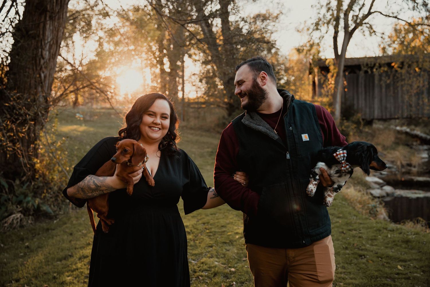 A couple in autumn attire poses outdoors with their pet dog. couples engagement