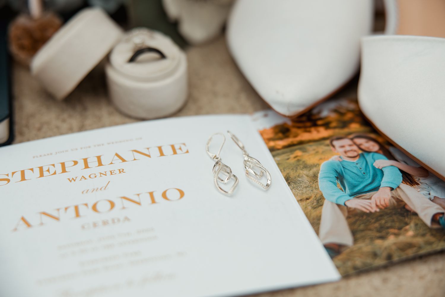 Wedding invitation cards with gold text and embellishments laid out on a decorative surface.