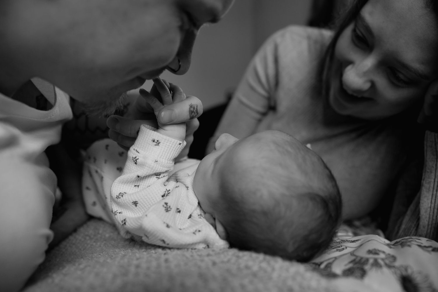 A black and white photo collage shows tender moments between a parent and baby in various intimate poses.