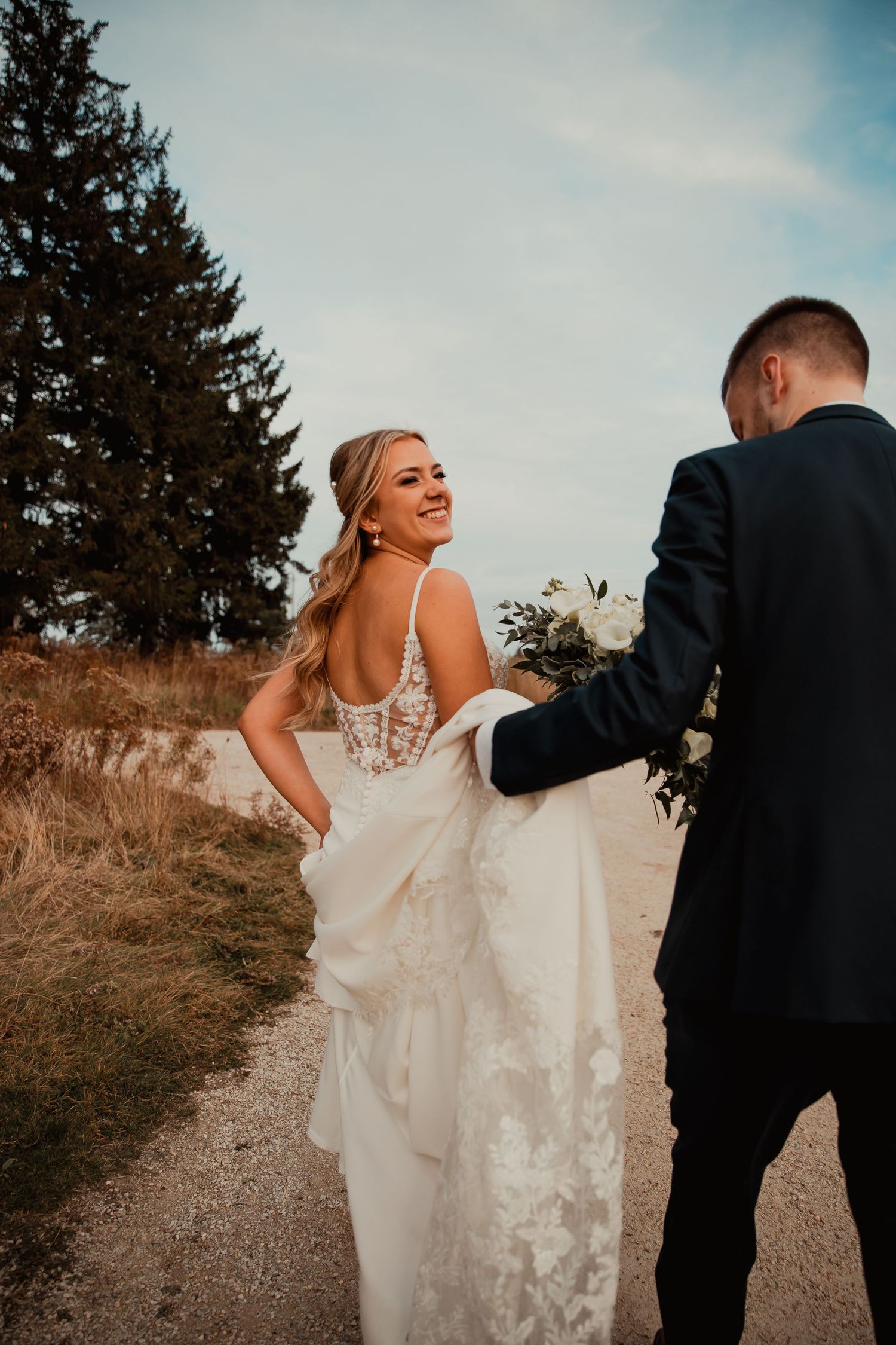 Couple laughing together on a countryside path during sunset. wedding