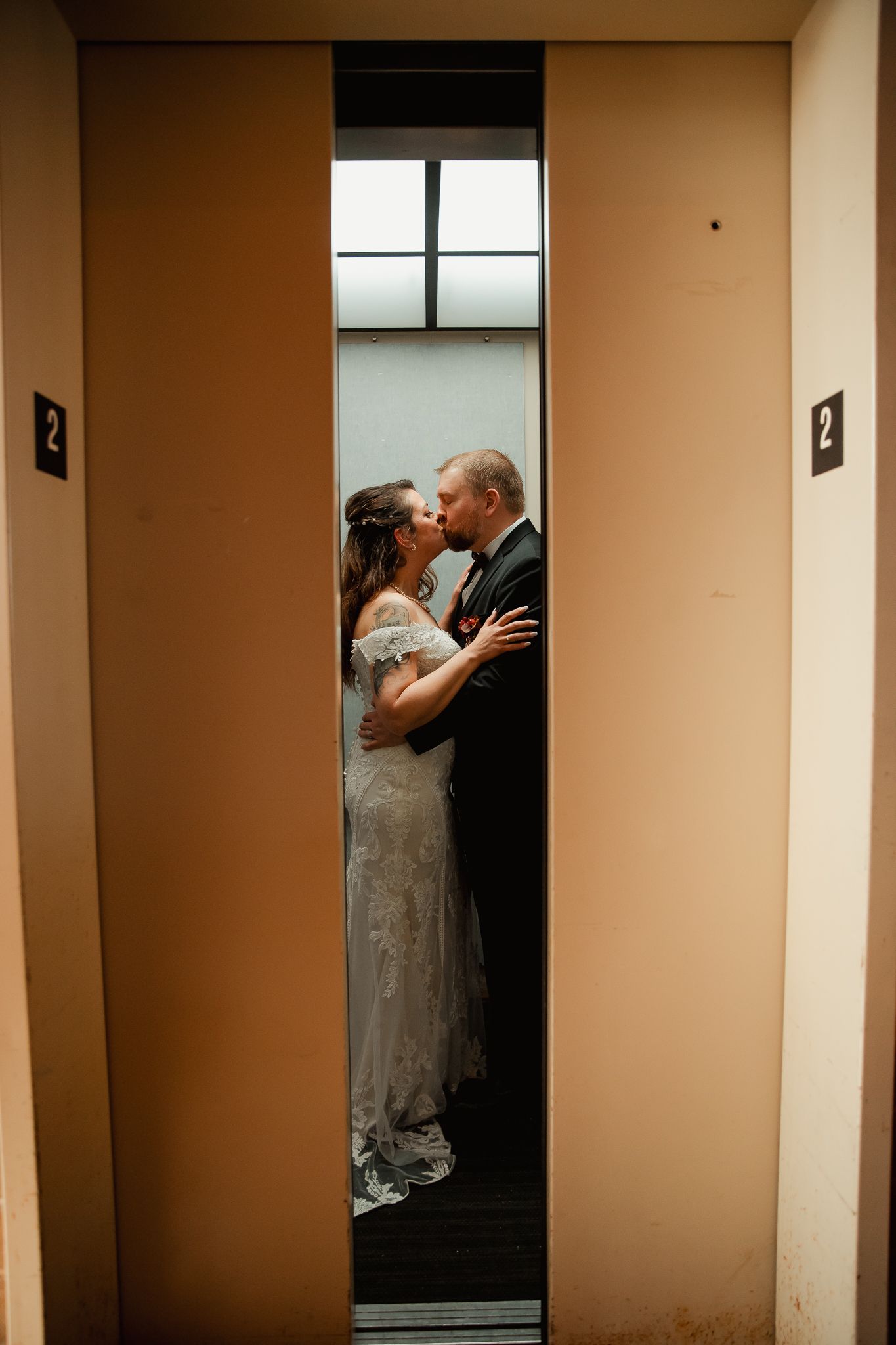 An intimate moment between newlyweds sharing a kiss in an elevator. wedding