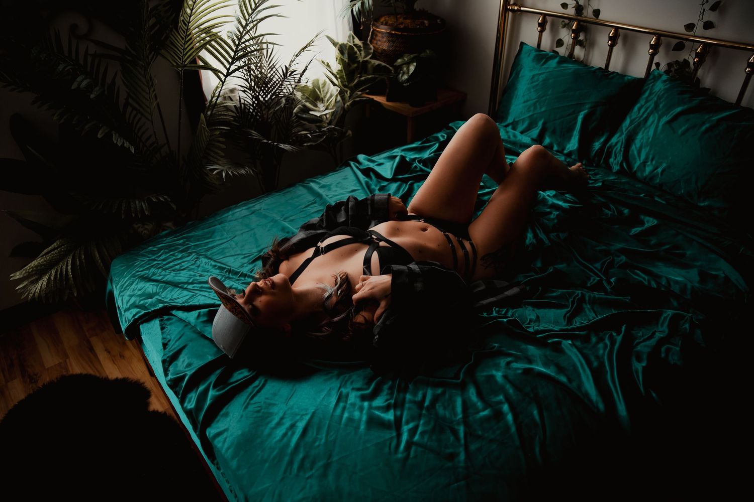 A series of dark and moody photographs with teal colored bedding and dramatic shadows in a bedroom setting.