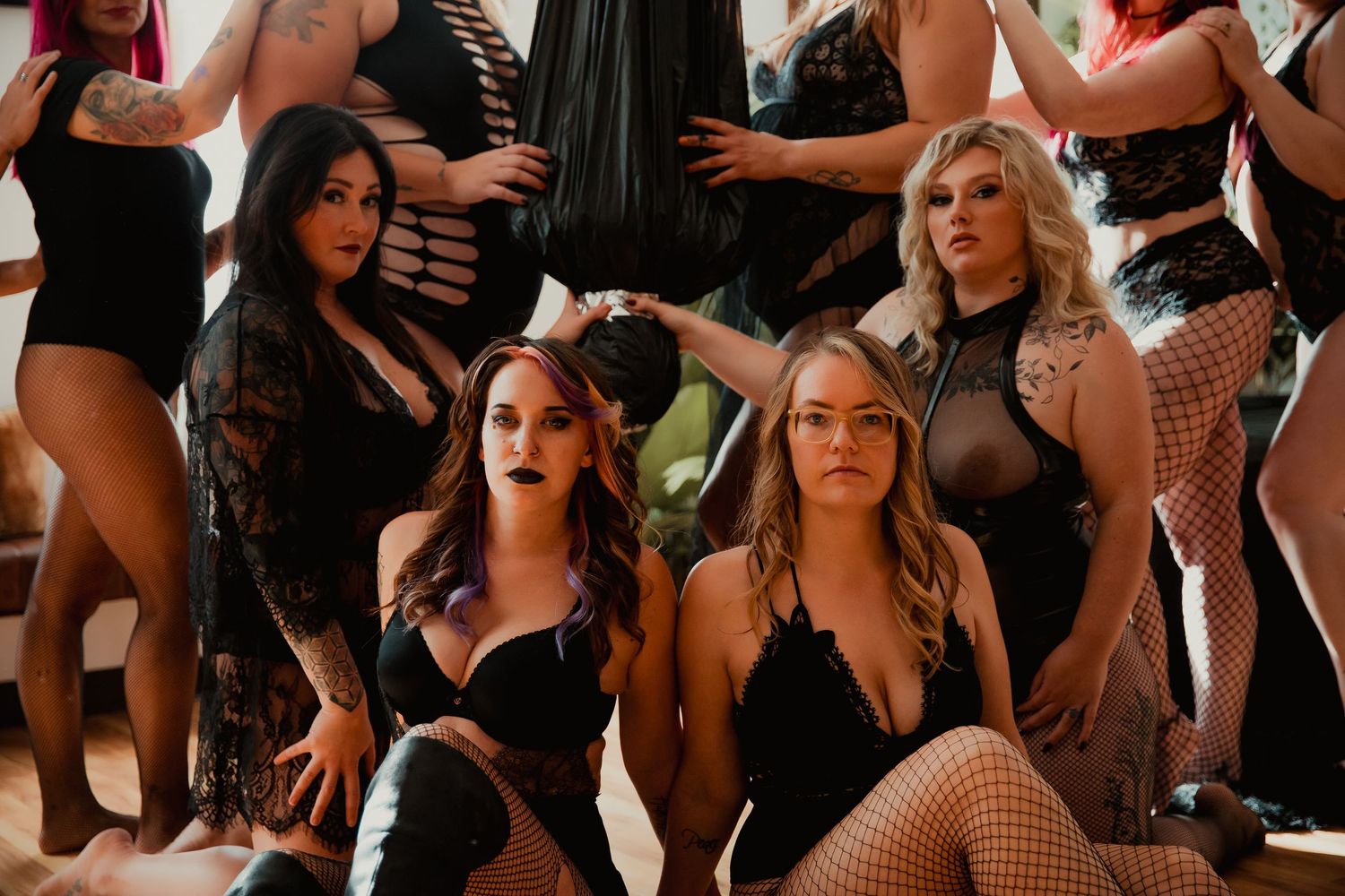 A crowded music festival scene shows concertgoers dancing and enjoying themselves in black outfits and summer clothing.
