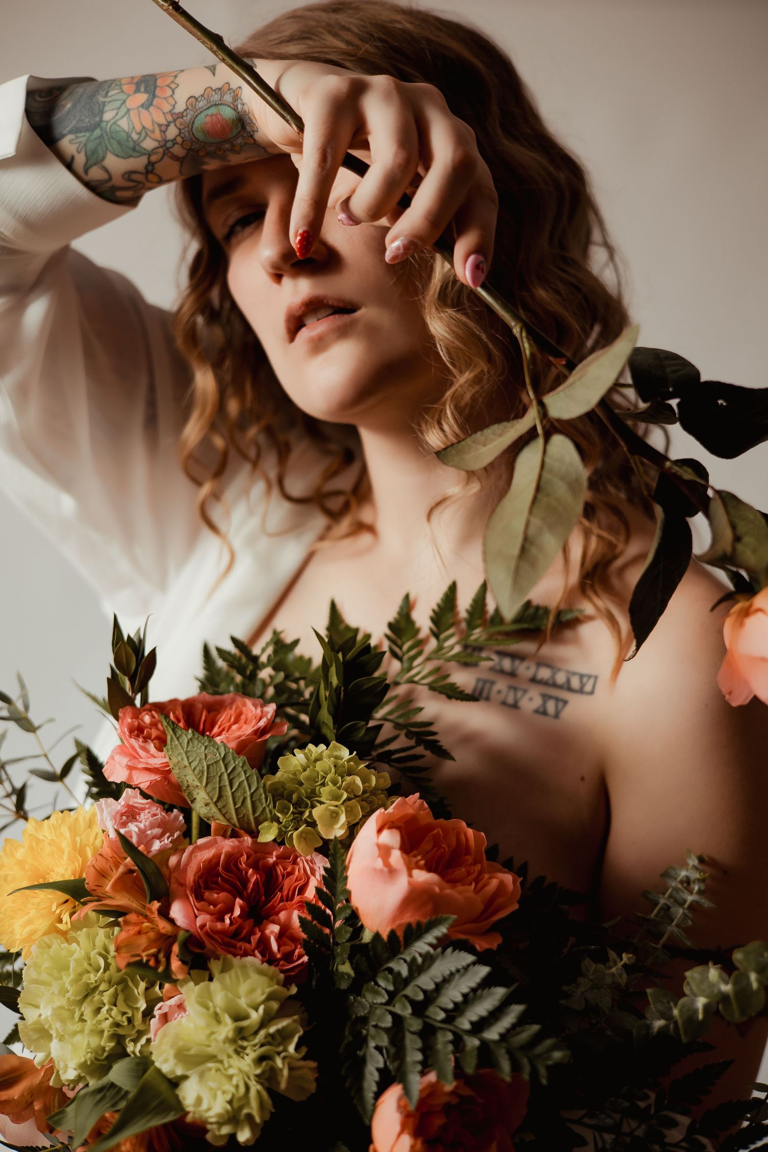 Artistic photo series showing hands holding a lush bouquet of coral roses and greenery against a soft beige background.