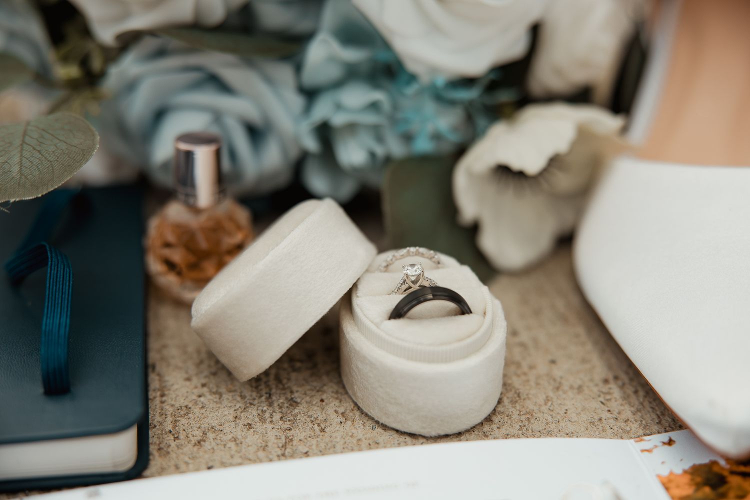 White decorative ceramic bowls and containers arranged on a textured granite countertop.