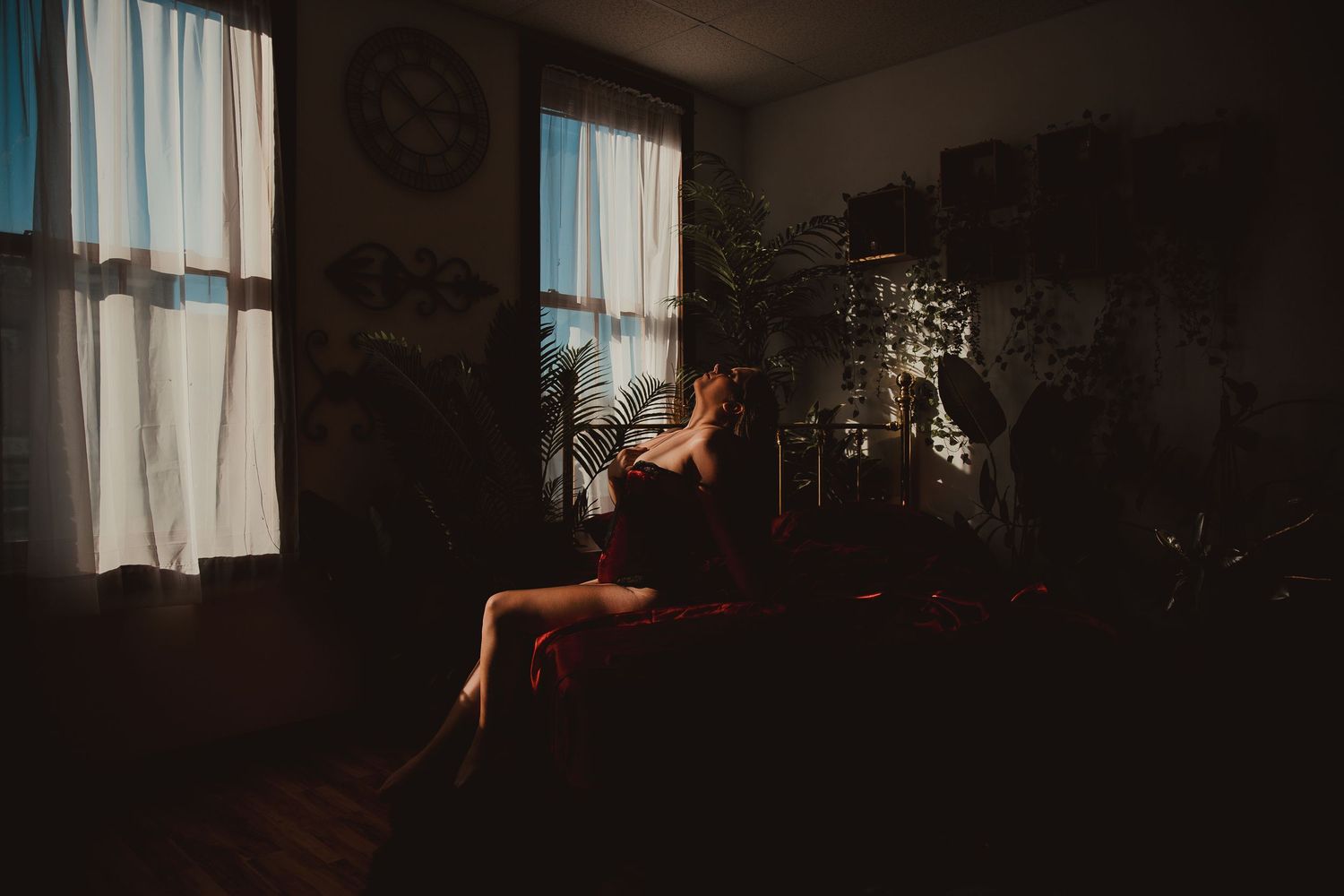 A dimly lit room with curtains and window light creating a moody, atmospheric interior scene.