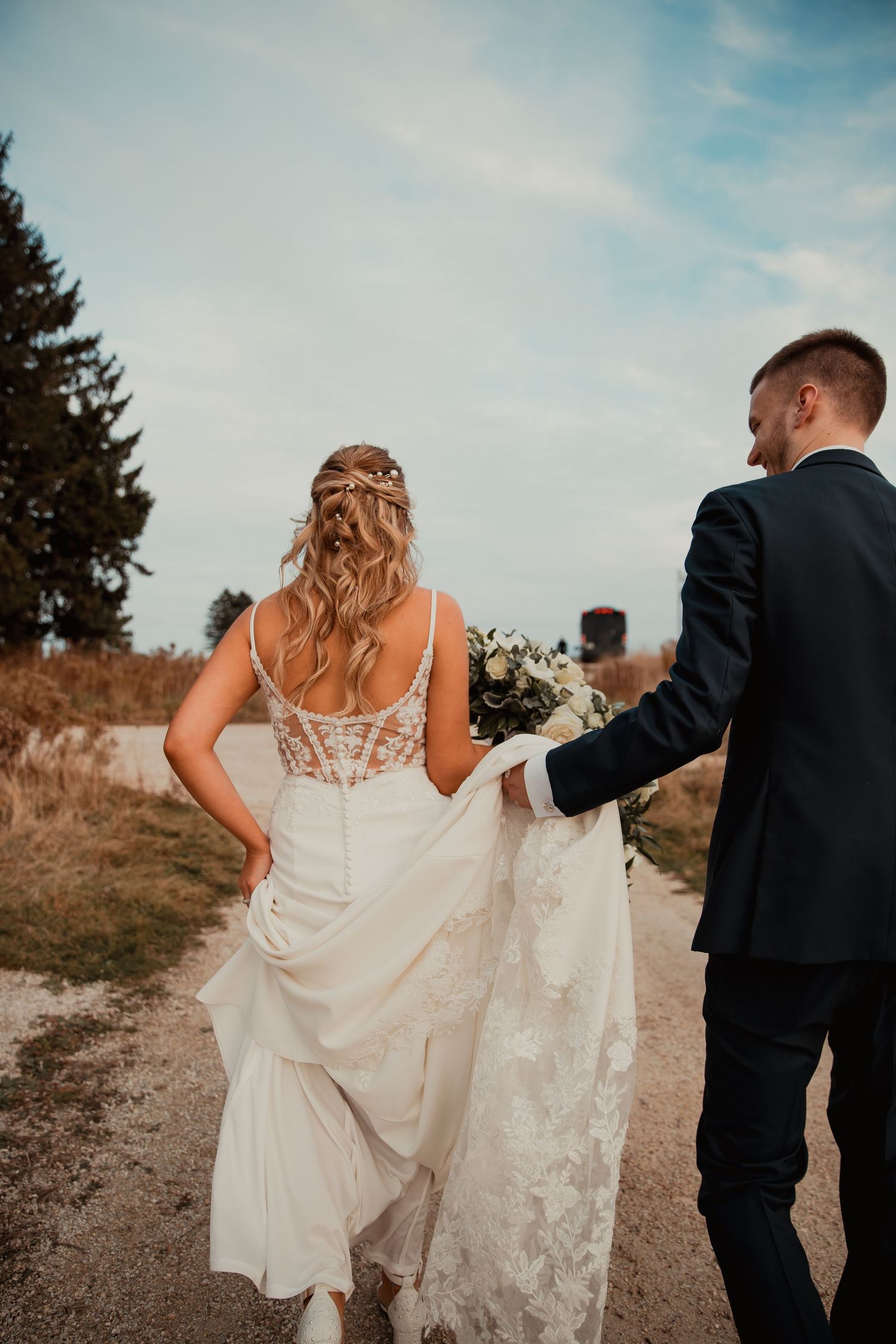 A couple walking down a rustic path with flowing white wedding dress. wedding