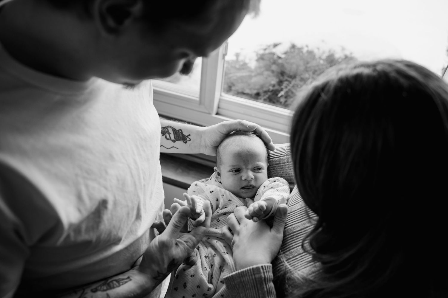 A series of black and white candid photographs showing intimate family moments and interactions.