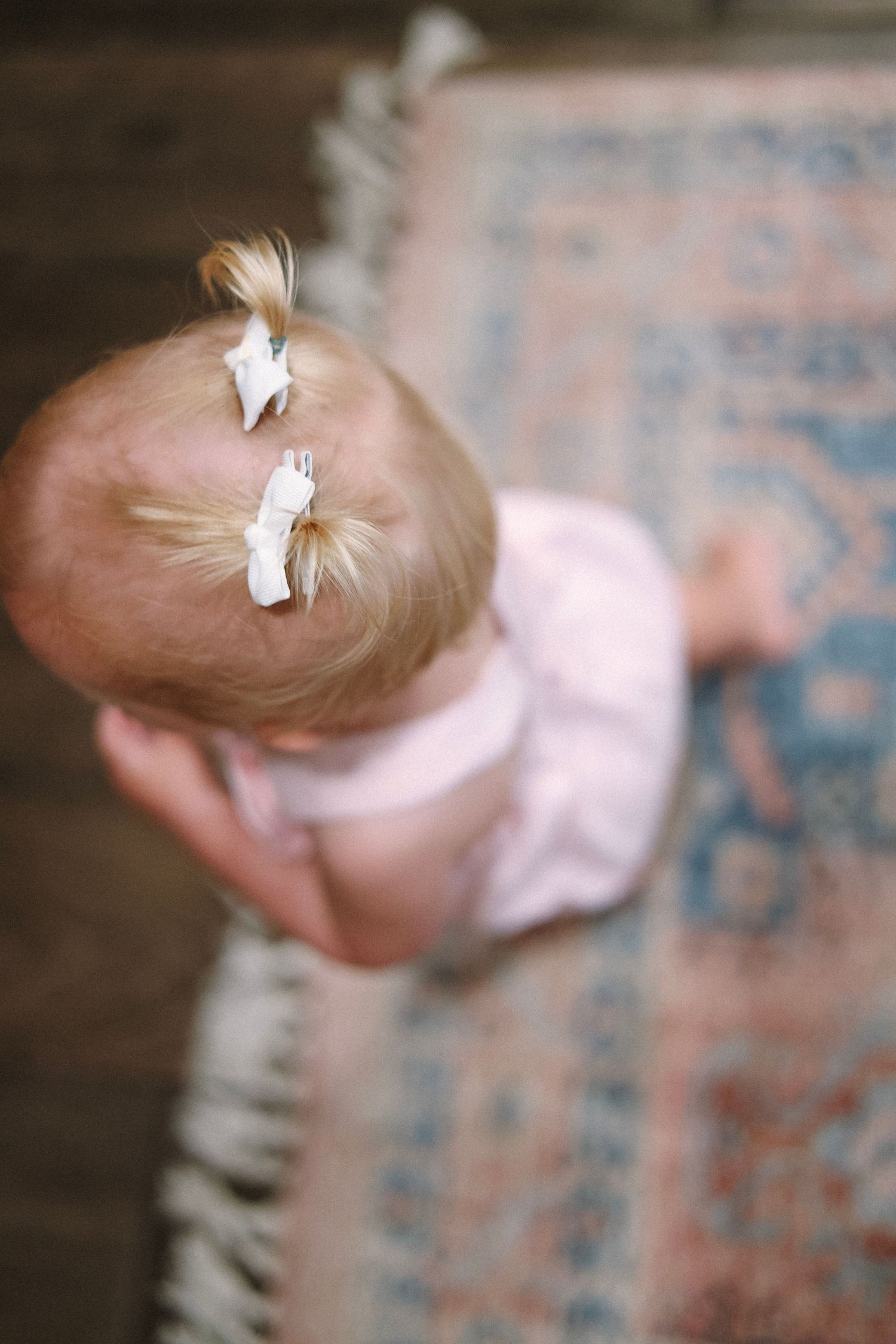 Abstract motion blur photography showing soft pink and beige tones against a textured background.