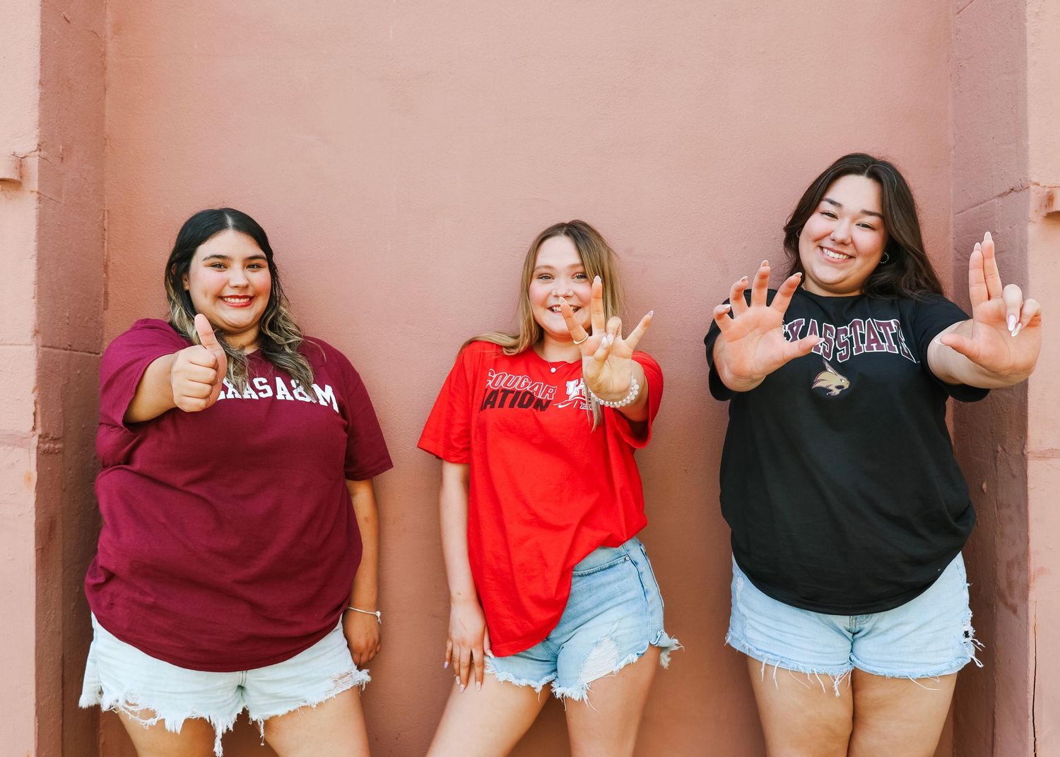 Group photo session against a pink wall showing matching outfits and fun poses.