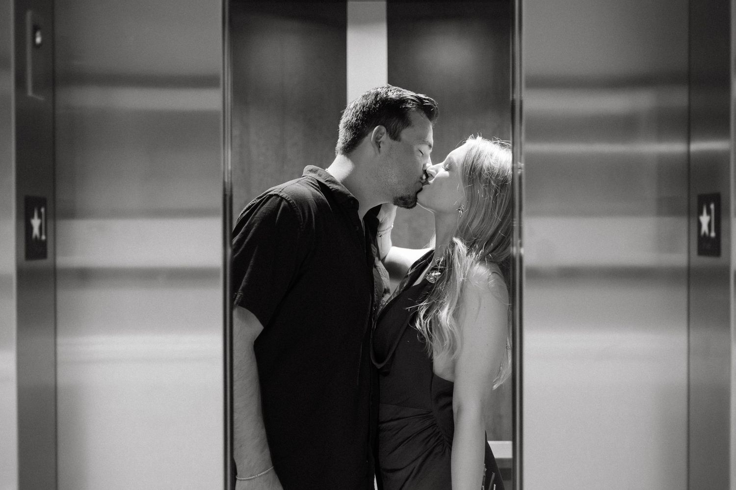 Black and white romantic couple kissing in elevator sequence.