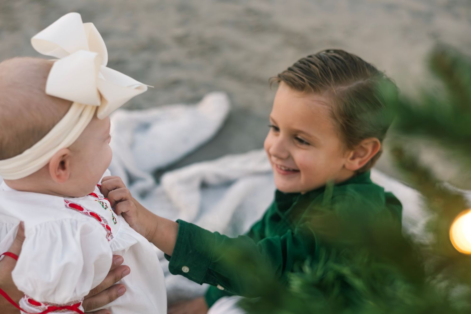 A family enjoys a festive outdoor gathering with white decor and string lights in a garden setting.