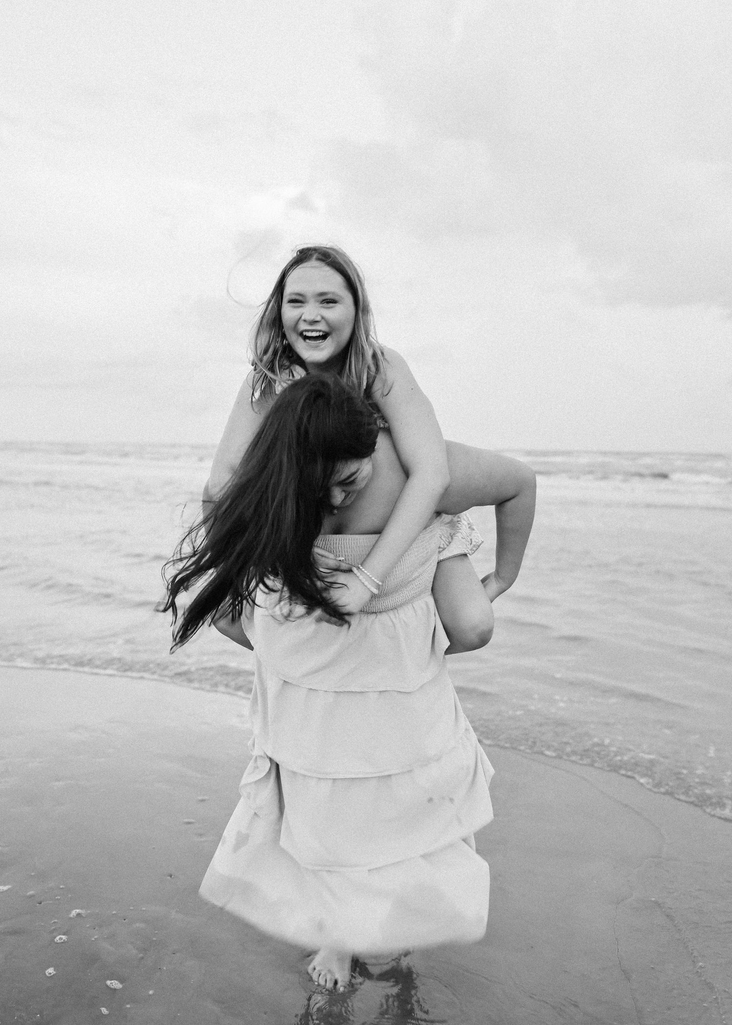 A series of joyful moments captured in black and white photos at the beach.