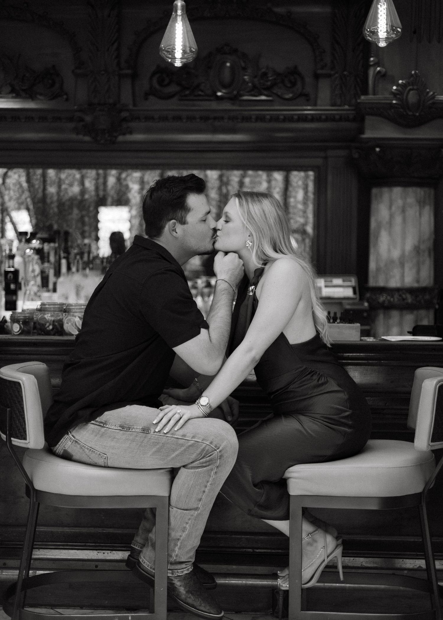 Intimate black and white photos of a couple on cushioned seating.