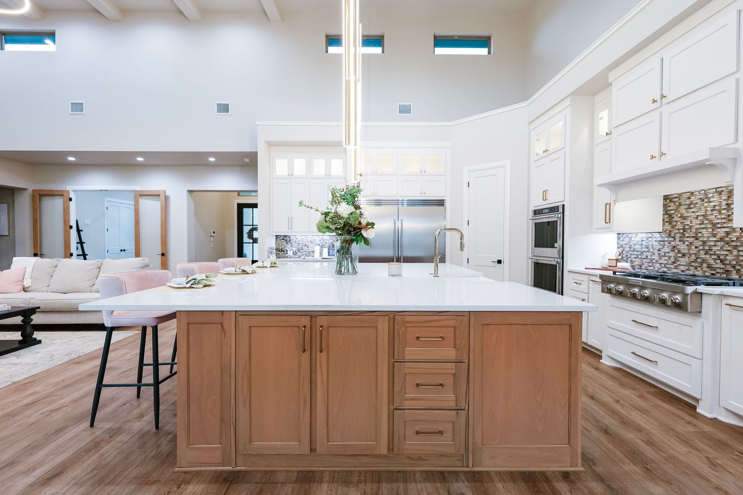 Modern white kitchen with long island and custom cabinetry spanning multiple angles.